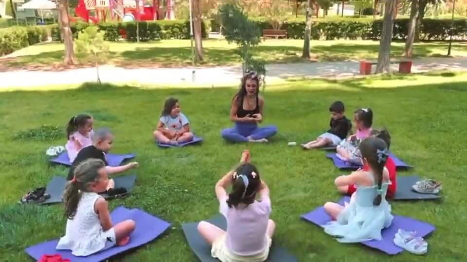 Açık havada yoga dersi yapan çocuklar